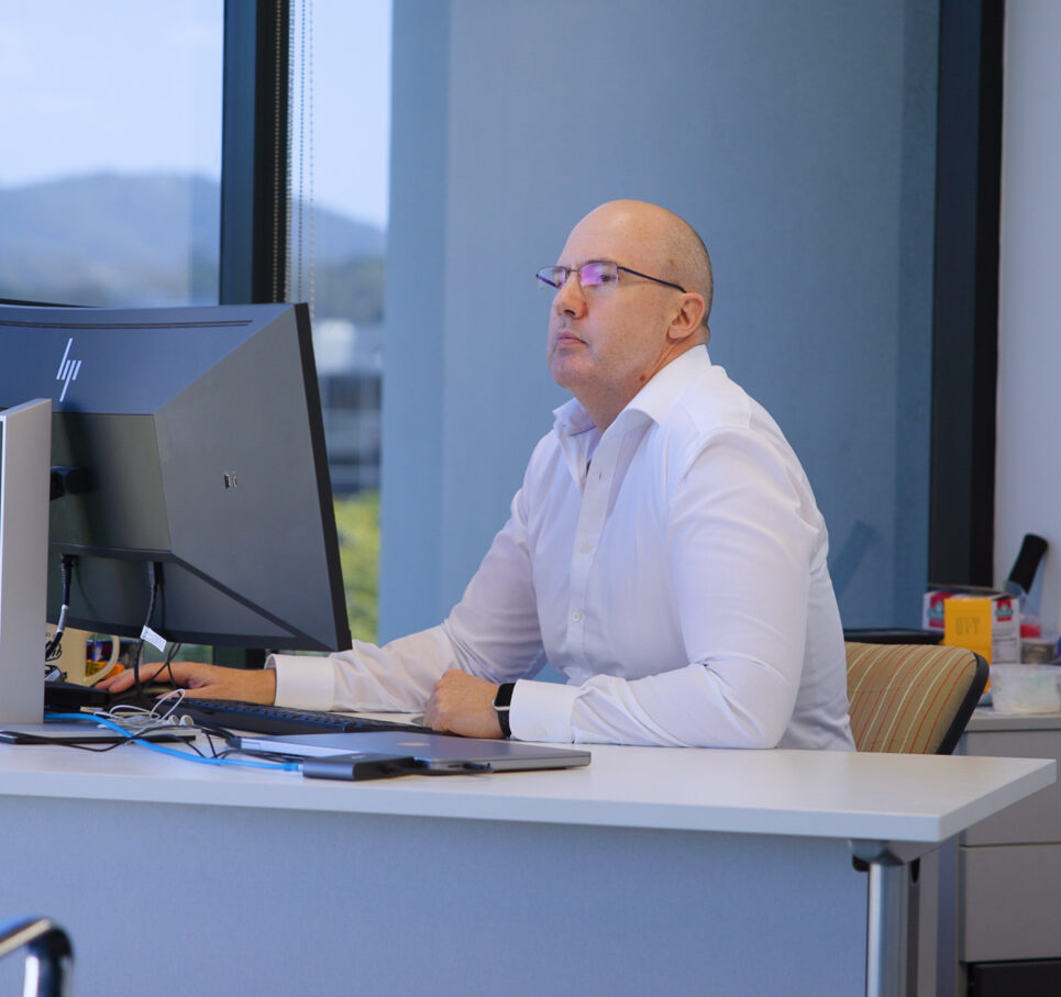 man seated at an office desk working on a laptop